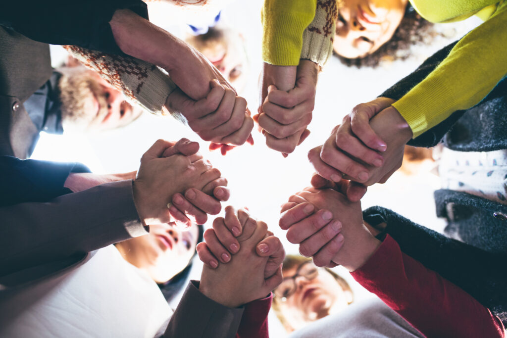 People who overcame addiction through residential rehab in Maplewood NJ holding each other by hands. Toned concept.